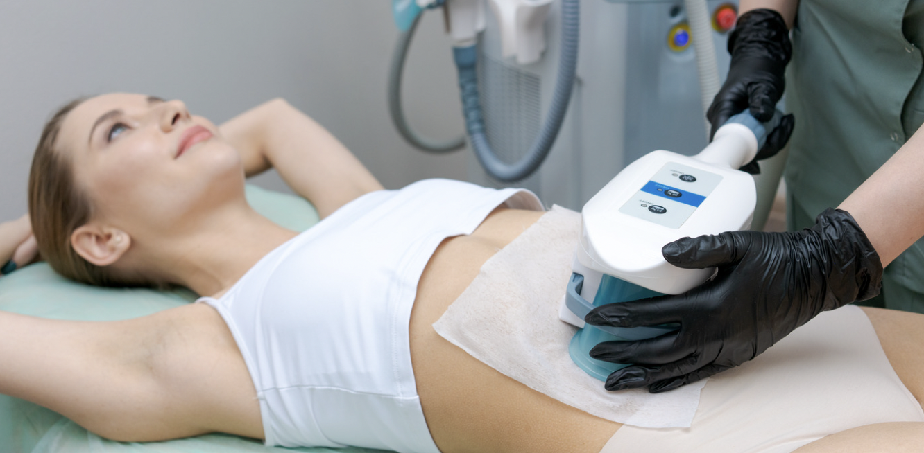 A woman is getting her belly brushed on the bed