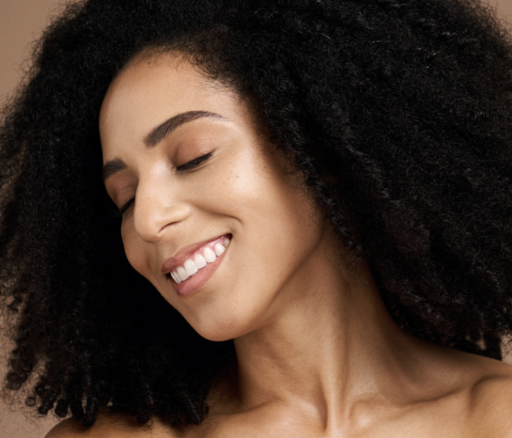 A woman with curly hair smiling for the camera.