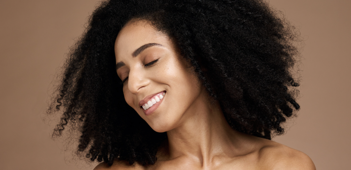 A woman with curly hair smiling for the camera.